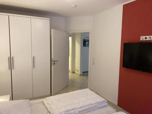 a bedroom with a bed and a flat screen tv at Wohnung 73 in Horumersiel