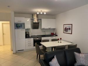 a kitchen and living room with a table and chairs at Wohnung 73 in Horumersiel