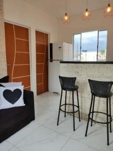 a living room with two chairs and a counter at Casa aconchegante no centro da cidade in São Thomé das Letras