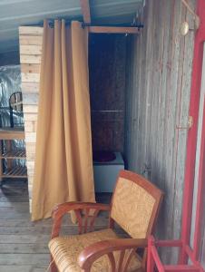 a room with two chairs and a curtain and a toilet at Le voyage de la salamandre in Brélidy
