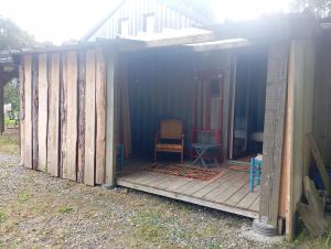 a house with a wooden deck with a table and chairs at Le voyage de la salamandre in Brélidy