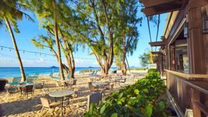 a beach with tables and chairs and the ocean at Divi Southwinds Beach Resort in Christ Church