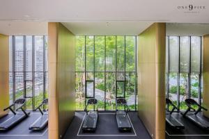 a gym with chairs and a large window at Near Central Rama 9 with Balcony, Pool, Gym & 5m to MRT in Bangkok