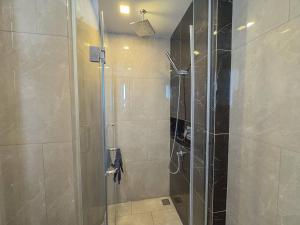 a shower with a glass door in a bathroom at Near Central Rama 9 with Balcony, Pool, Gym & 5m to MRT in Bangkok +32 photos