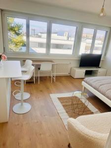 The Minimalist free Parking في Pully: غرفة معيشة مع أريكة وطاولة وكراسي