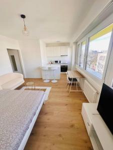 The Minimalist free Parking في Pully: غرفة بيضاء مع سرير ومطبخ