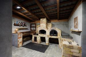 a large kitchen with a stone oven in a room at Șura lu' Aurel in Gîrdani