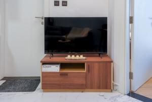 ein Wohnzimmer mit einem TV und einem Holztisch in der Unterkunft 1 BR in Maryah Island with balcony in Abu Dhabi + 6 Fotos