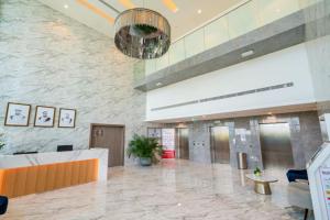een lobby van een ziekenhuis met een receptiebalie en een kroonluchter bij Park View Saadiyat Chic 1 BD in Mushayrib +19 foto's