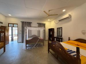 una camera da letto con un letto con zanzariera di kuda Bay Surf Hostel ad Arugam