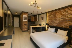 a bedroom with a white bed and a brick wall at Riverside Industrial Studios - SAUNA - GYM -air-conditioning-SPA-FITNESS in Wrocław