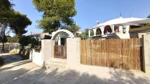 a fence in front of a house with a gate at Irini Garden House in Vathí