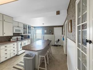 a kitchen with white cabinets and a large island at Brownfield BlueBird House - 6 bedrooms in Brownfield