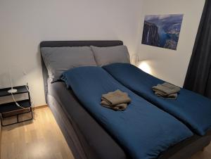 een bed met blauwe lakens en handdoeken erop bij Bright Fjord View Apartment Jørpeland in Jørpeland
