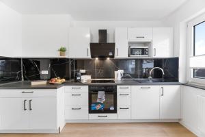 a kitchen with white cabinets and a stove top oven at Elite Weser Apartments in Bremen