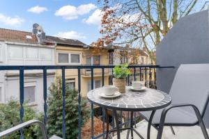 a balcony with a table and two cups on it at Elite Weser Apartments in Bremen