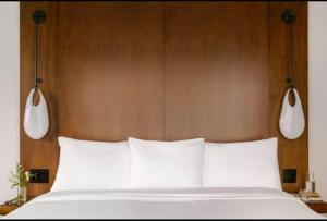 a bed with a wooden headboard and two lights above it at Merchant LES in New York