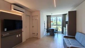 a living room with a couch and a table with chairs at Mila Rooftop - Praia de Tamandaré in Tamandaré