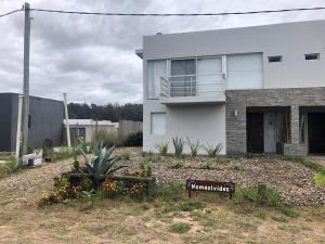 ein weißes Haus mit einem Schild davor in der Unterkunft Nomeolvides Ocean Park Casa in Ocean Park