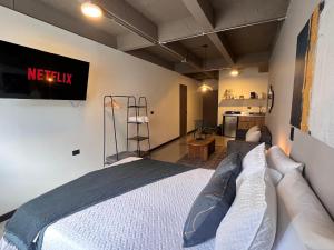 a bedroom with a bed and a television on the wall at 104-105 Hermoso y cómodo ambiente para grupos in Medellín