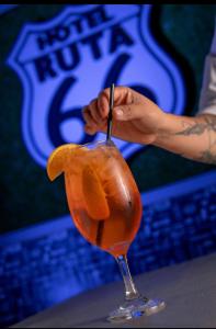 a person is stirring a drink in a martini glass at HOTEL RESTAURANTE Ruta 66 in Paso de los Libres +26 photos