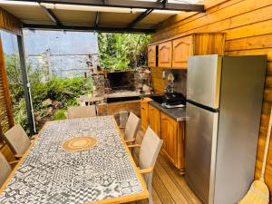 a kitchen with a table and a refrigerator at LaKaz à Eva in Cilaos