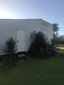 una casa con una puerta blanca y algunas plantas en Eco Tiny House, en Algarrobo