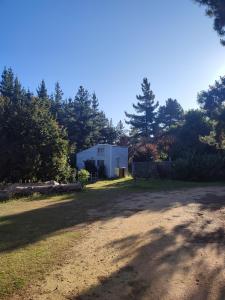 un camino de tierra frente a un edificio blanco en Eco Tiny House, en Algarrobo
