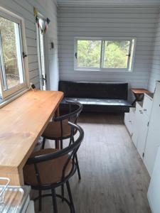 Una pequeña casa con un banco en el medio. en Eco Tiny House, en Algarrobo