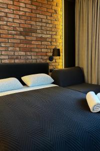 a bedroom with a bed and a brick wall at Riverside Industrial Studios - SAUNA - GYM -air-conditioning-SPA-FITNESS in Wrocław +10 photos