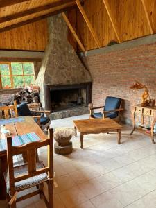ein großes Wohnzimmer mit einem Steinkamin in der Unterkunft Hostería Altas Cumbres in El Chalten