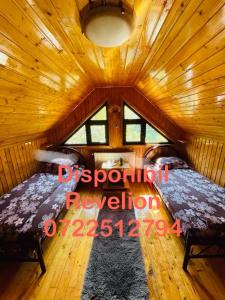 ein Zimmer mit zwei Betten in einer Holzhütte in der Unterkunft Vila Maria Dambovicioara in Dâmbovicioara