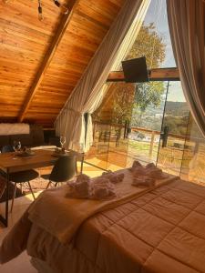 a bedroom with a large bed and a large window at chale aster camping santa barbara in Francisco Beltrão