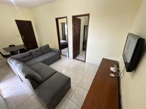 a living room with a couch and a flat screen tv at Baratinho 2 quartos no ribeiro de abreu in Belo Horizonte