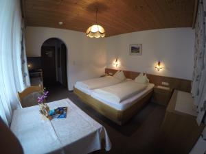 トゥクスにあるGästehaus Alpenlandのベッドルーム1室(ベッド2台、テーブル2台付)