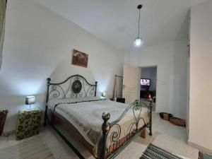 a bedroom with a large bed in a white room at Maison hôte Dar Traki in Tozeur