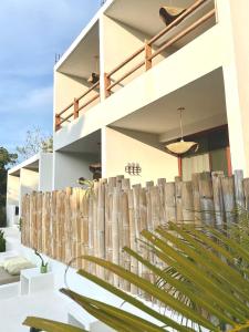 a house with a wooden fence in front of it at Kasa Koh in Brisas de Zicatela