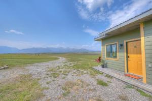 ein grün-gelbes Haus mit einem unbefestigten Weg daneben in der Unterkunft Echos and Embers Waterton in Waterton Park + 3 Fotos