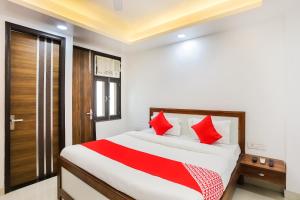 a bedroom with a large bed with red pillows at Super Hotel O Kazhakkoottam Near Technopark Phase 3 in Trivandrum