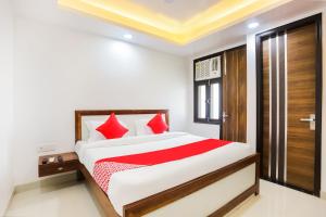 a bedroom with a large bed with red pillows at Super Hotel O Kazhakkoottam Near Technopark Phase 3 in Trivandrum