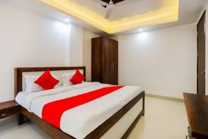 a bedroom with a large bed with red pillows at Super Hotel O Kazhakkoottam Near Technopark Phase 3 in Trivandrum