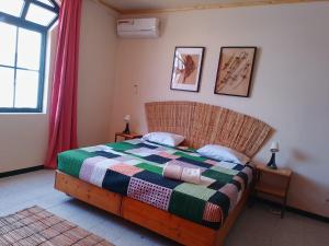 a bedroom with a bed with a colorful blanket at Essencia Sterra in Praia
