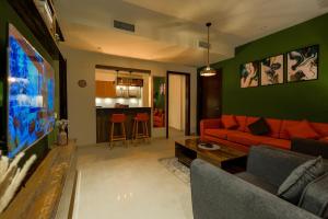 sala de estar con sofá rojo y paredes verdes en Penta Square Signature Hotel Apartments - DHA Phase 5 Lahore, en Lahore