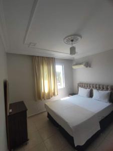 a bedroom with a large white bed and a window at Marin Apart Arsuz in Arsuz