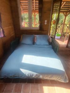a large blue bed in a room with windows at Cabane atypique sur une Île in Sury-aux-Bois +66 photos