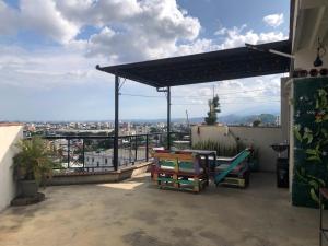 a patio with a table and chairs on a roof at La Curva Apartamentos in Cali