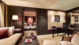 Una sala de estar con un sofá y un escritorio. en Banyan Tree Bangkok, en Bangkok