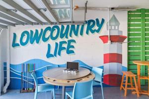 una mesa y sillas con un ordenador portátil encima en Luxury 6 Br Sleeps 18 Private Heated Pool Fire Pit, en Hilton Head Island