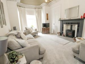 a living room with a couch and a fireplace at Rowan Tree House in Brechin