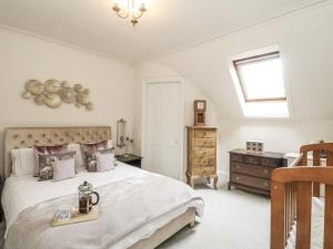 a bedroom with a large bed and a window at Rowan Tree House in Brechin